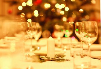Table prepared for a family celebration dinner with a tradtional Christmas tree in the background